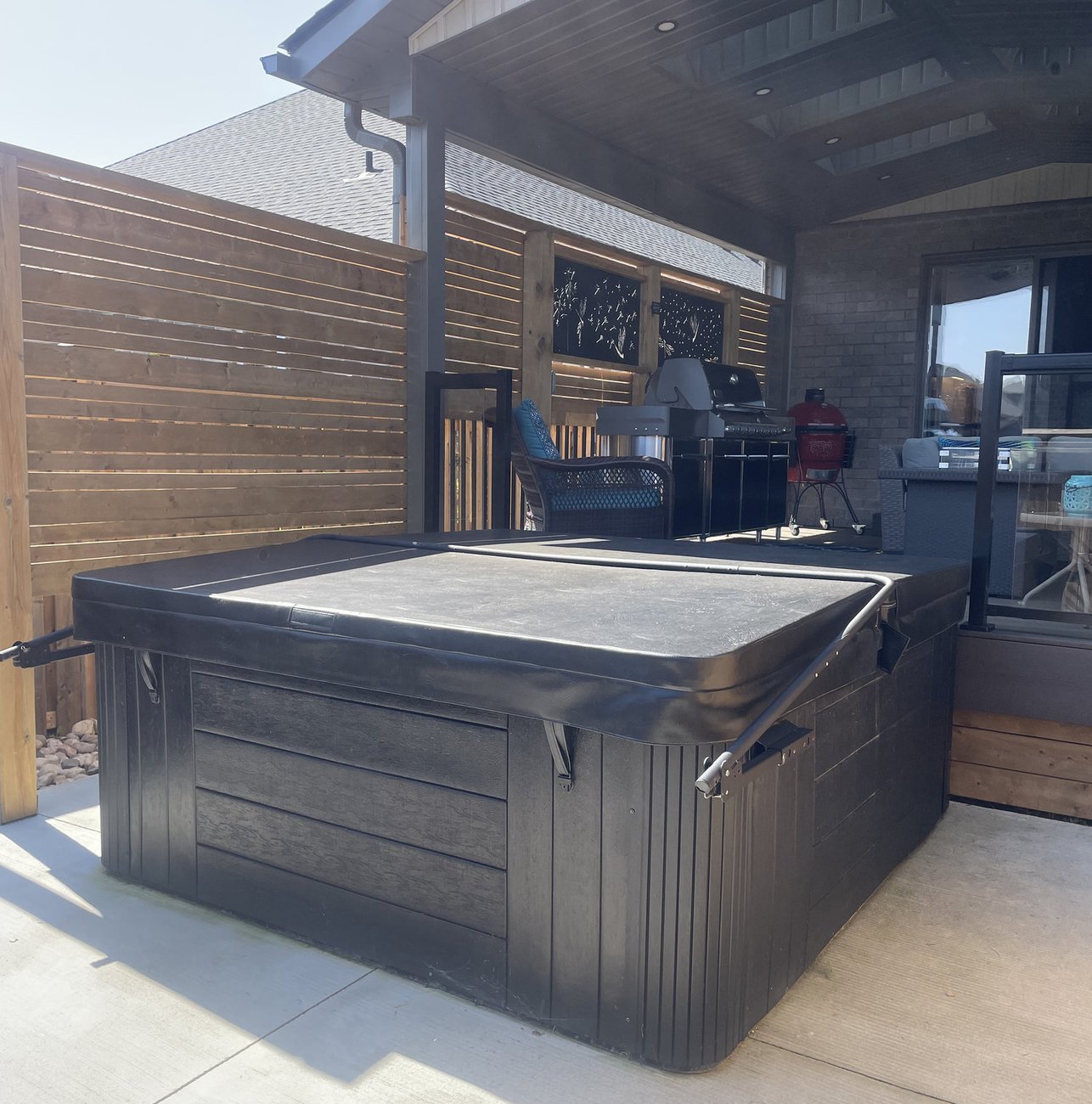 covered porch with cedar privacy screen and hot tub built in Woodstock ON