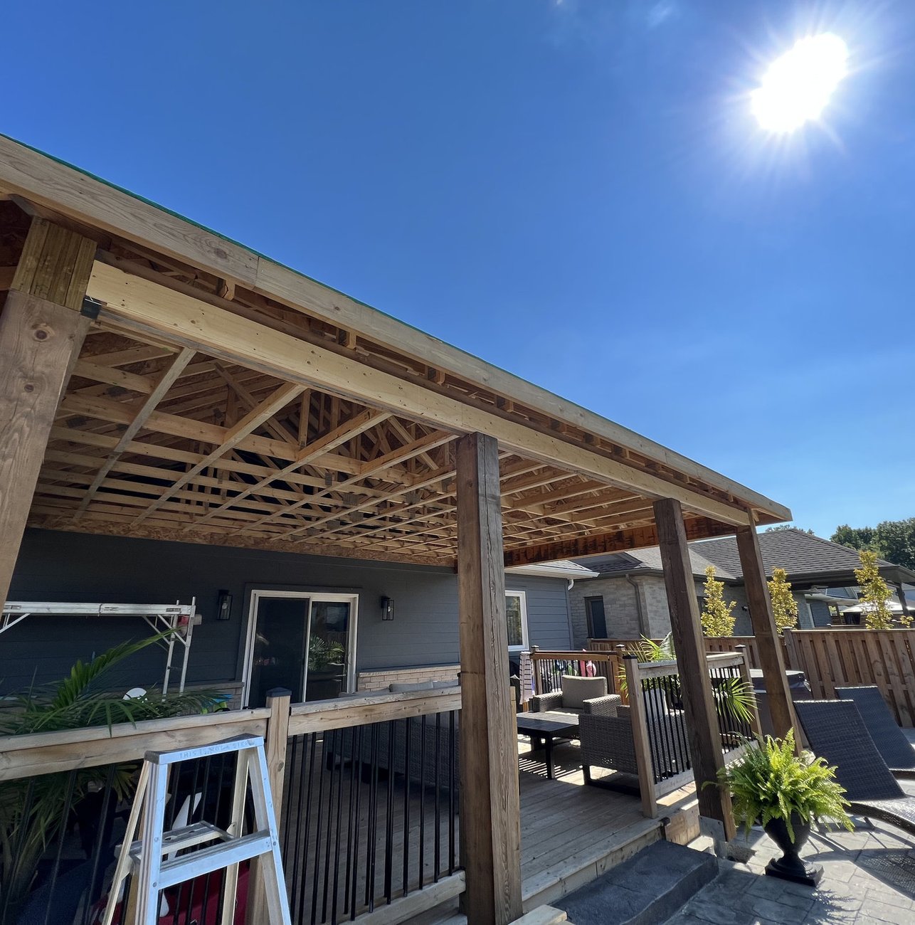 timber frame covered porch under construction on a Woodstock ON home, posts and roof trusses exposed
