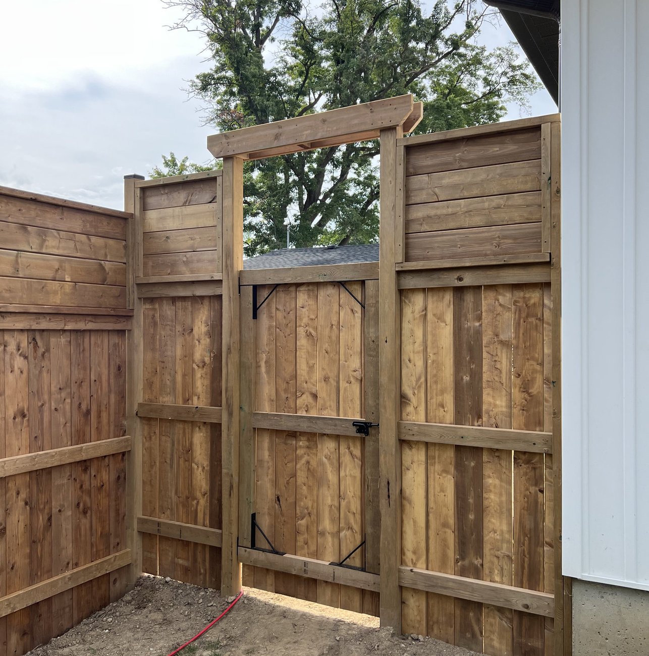 cedar privacy fence and gate with timber arbour built by Baird Construction in Woodstock ON