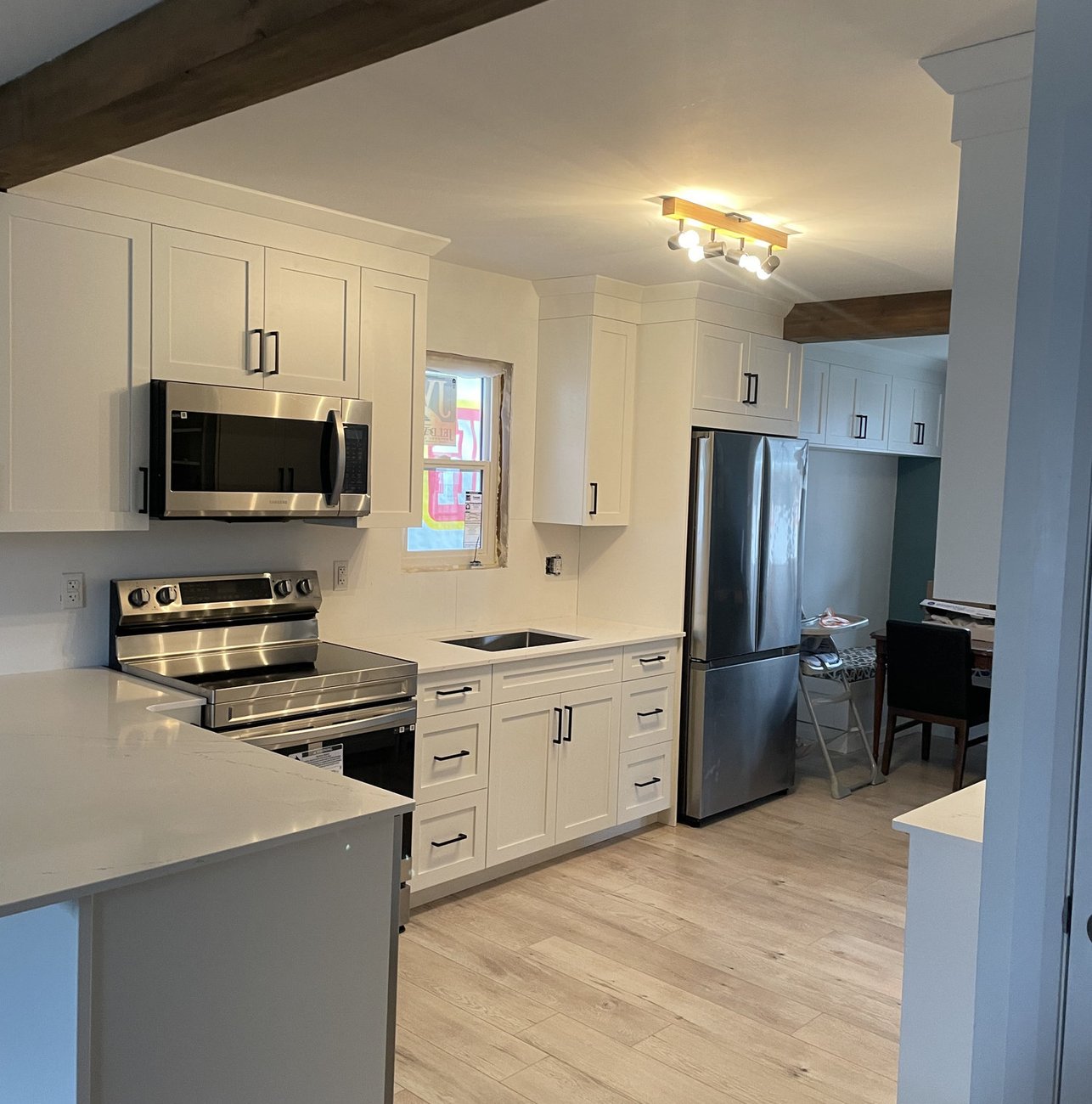 renovated white shaker kitchen with quartz counters and exposed beam in a Woodstock ON home